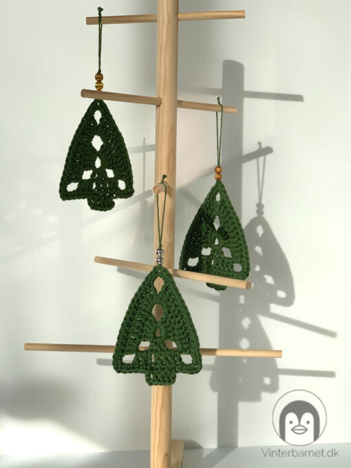 3 mørkegrønne juletræer. Hæklet i tykt bomuldsgarn, med pynte perler på snoren som bruges til at hænge dem op med.